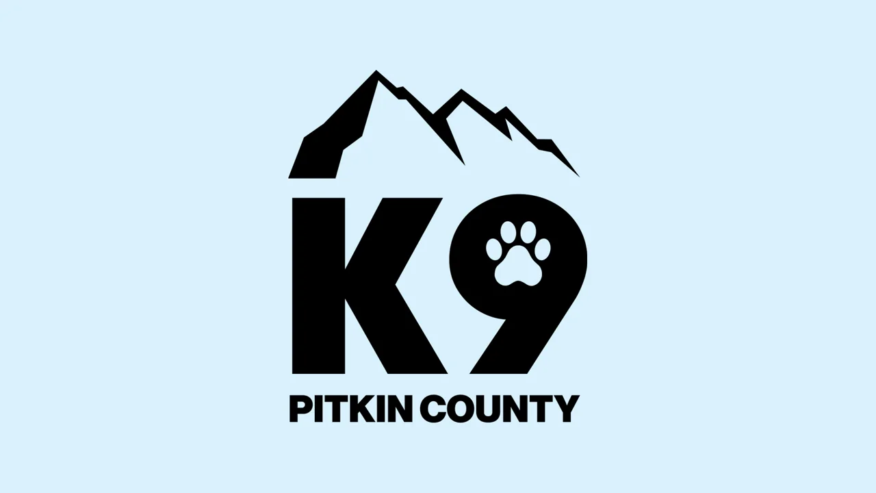 Pitkin County K9 logo with mountains and a paw print on a light blue background